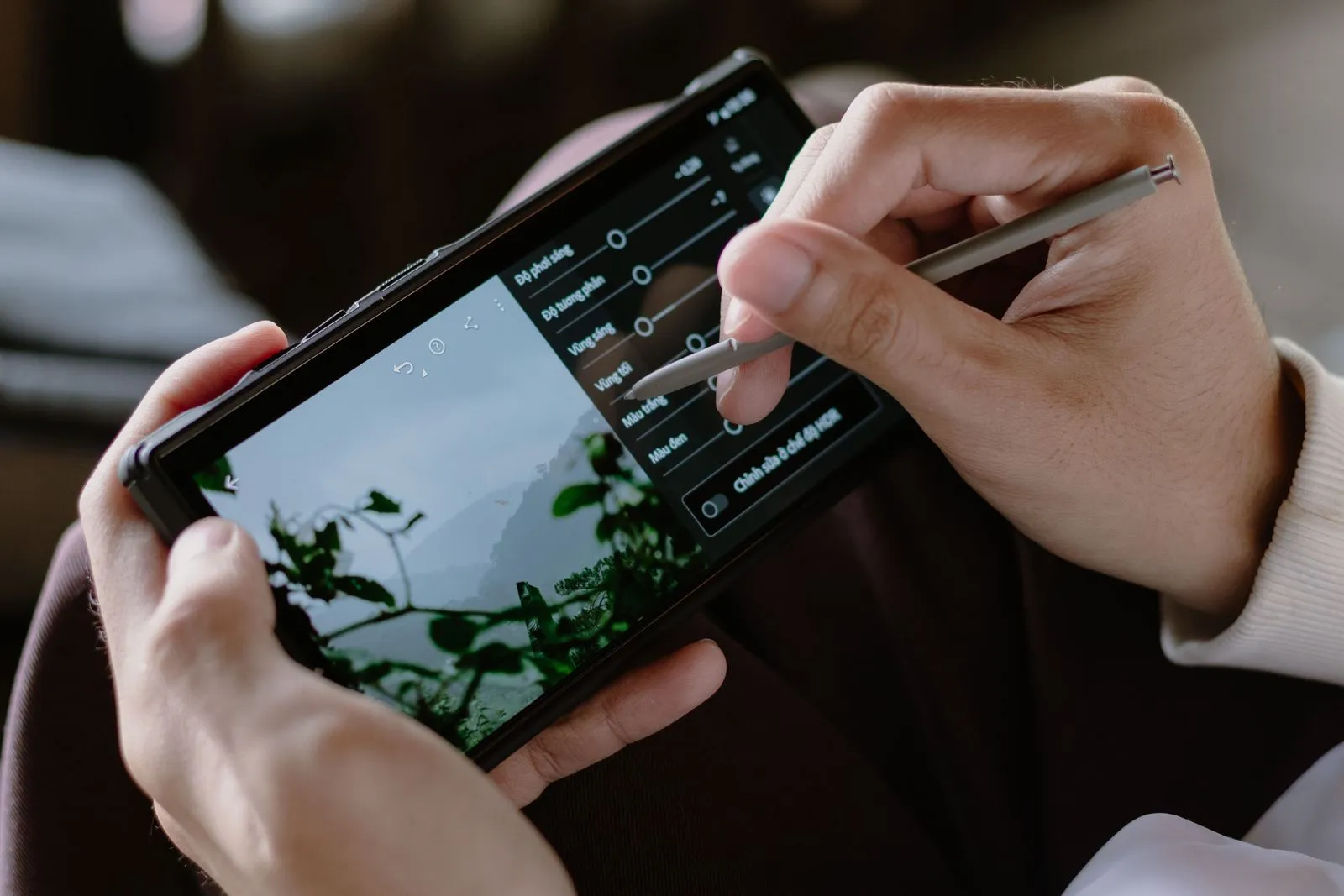 Hände stellen am Smartphone Belichtung und Kontrast eines Fotos ein