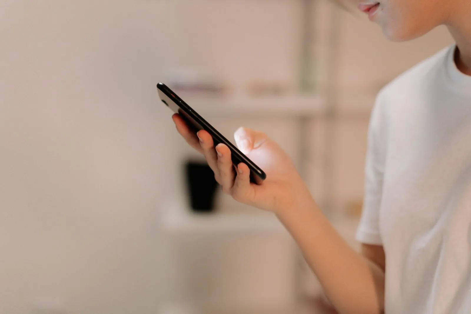 Eine Person hält ein Smartphone in der Hand und liest auf dem Bildschirm