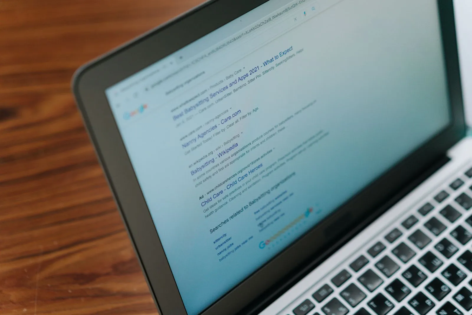Laptop mit einer geöffneten Google-Ergebnisseite auf einem Holztisch
